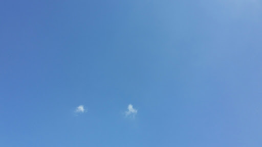 Clear blue skies with 2 small puffs of clouds