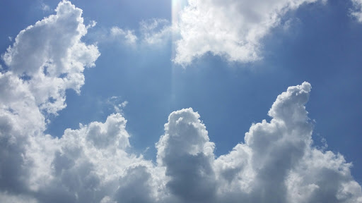 Blue skies, clouds and sun beaming